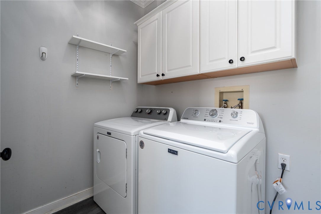 White shaker-style cabinetry with dark hardware, open shelving, and wood-finish flooring