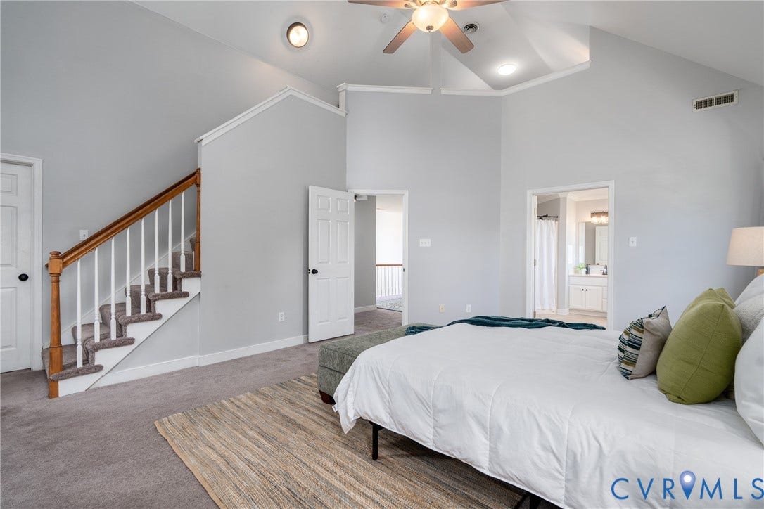 Vaulted ceiling with a ceiling fan, carpeted flooring, staircase with wood handrail, recessed lighting, and a paneled interior door