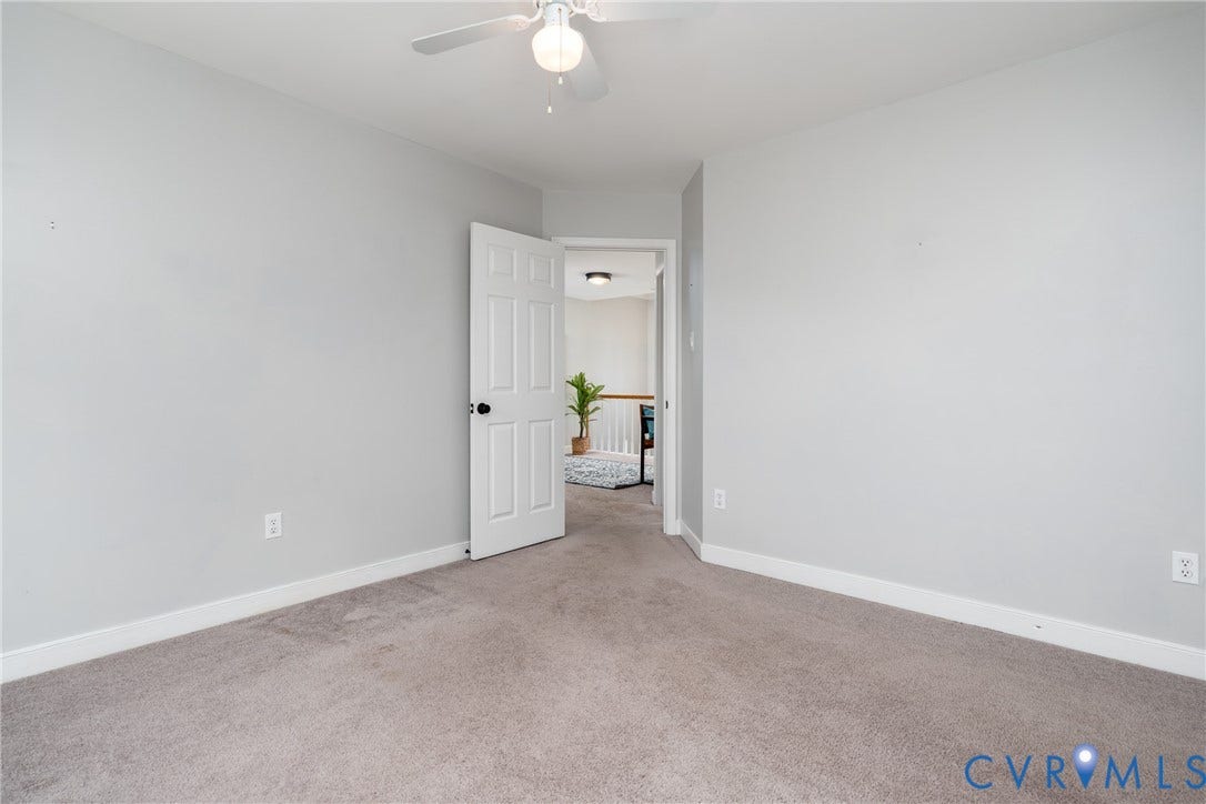 Neutral wall color, carpet flooring, ceiling fan, white paneled door