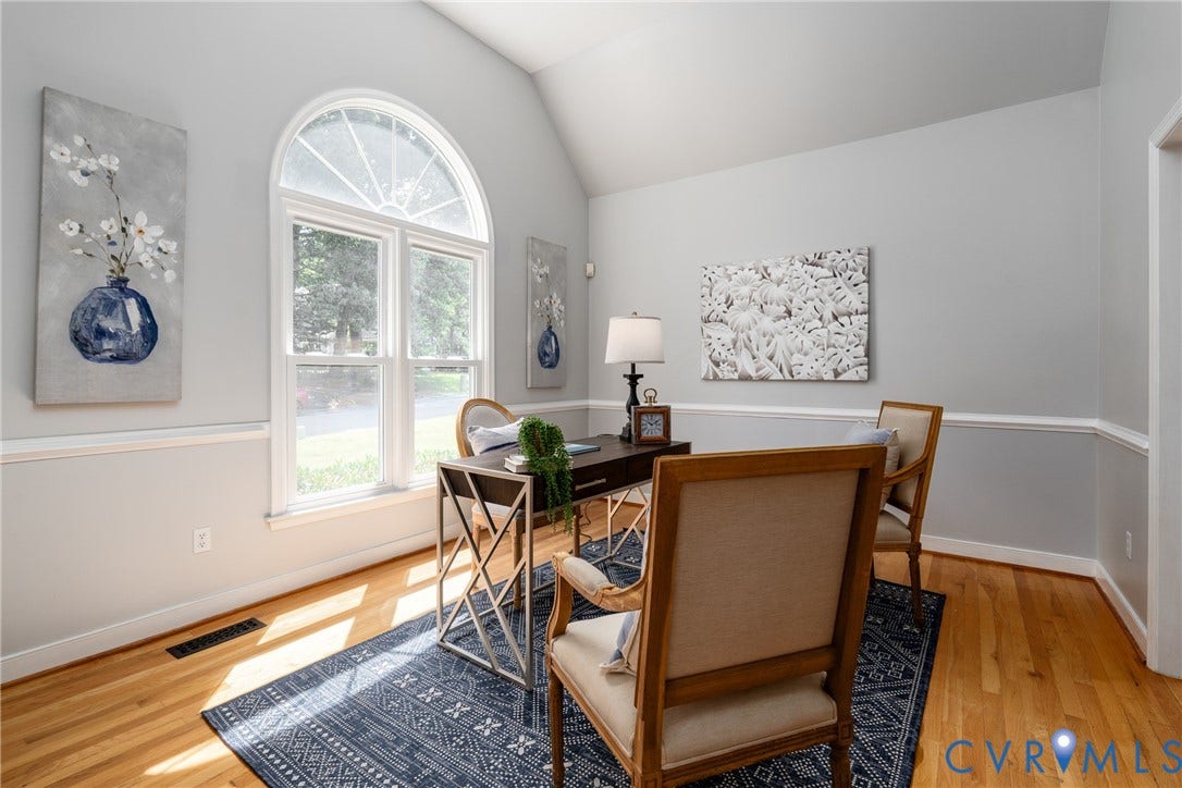 Vaulted ceiling, arched window, wood flooring, chair rail molding, and crown molding