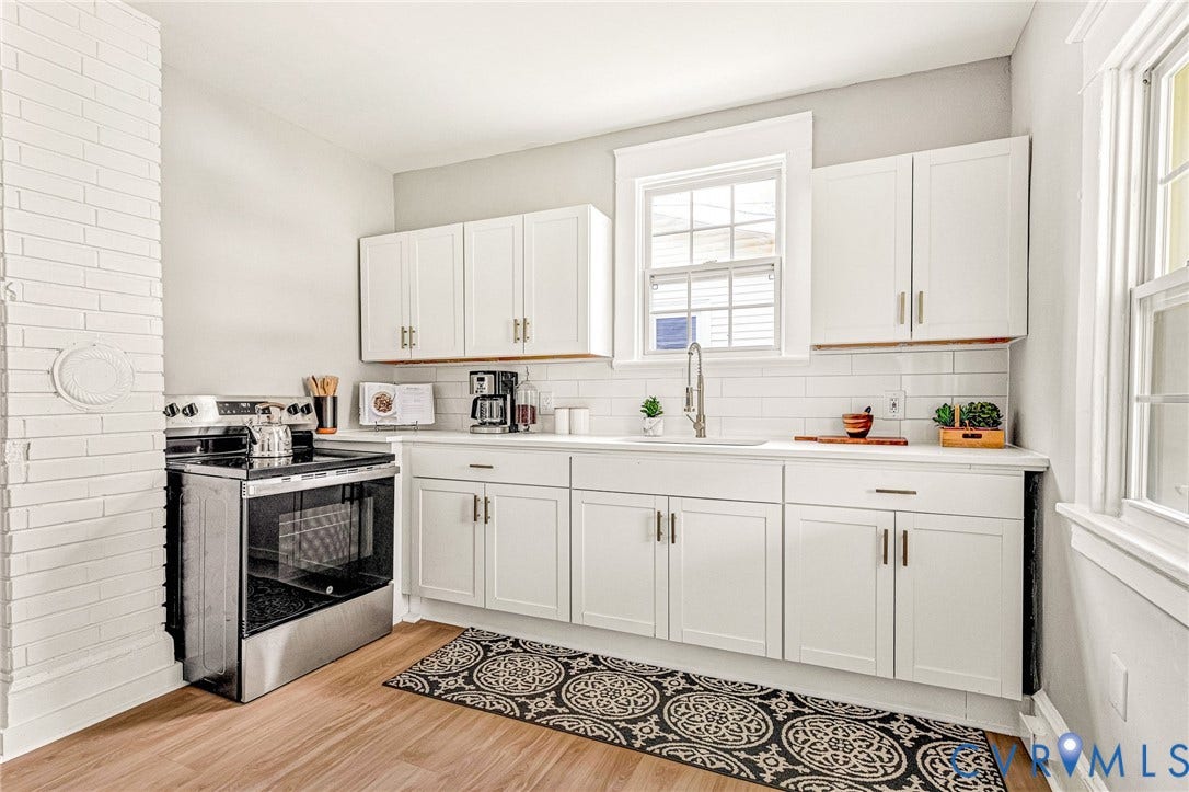 403 Masonic Lane, Masonic, Henrico, VA 23223 White shaker-style cabinetry, white subway tile backsplash, stainless steel range, wood-finish flooring, and a single-basin sink with a pull-down faucet