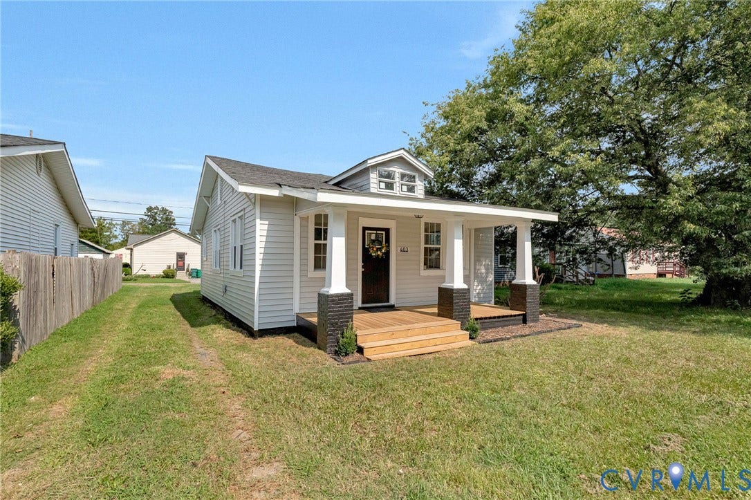 403 Masonic Lane, Masonic, Henrico, VA 23223 White horizontal siding exterior with a covered porch, wood-finish porch decking, and dark stone-clad porch column bases