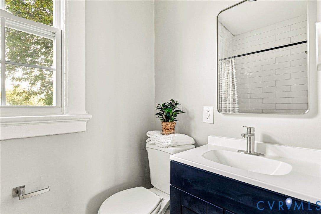 403 Masonic Lane, Masonic, Henrico, VA 23223 White subway tile shower surround, contemporary vanity with white countertop, chrome faucet, and rectangular mirror