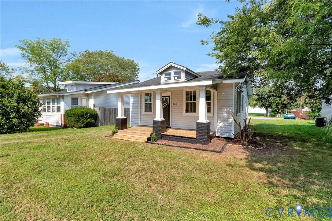 403 Masonic Lane, Masonic, Henrico, VA 23223 White siding exterior with a dark-paneled front door, covered porch with white columns, and a dormer window