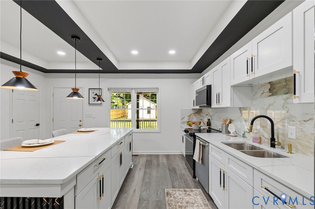 409 S Jefferson Street, Bolling, Petersburg, VA 23803 Kitchen featuring a large island with seating, white shaker cabinetry, an undermount double basin sink, stone countertops, and wood-finish flooring