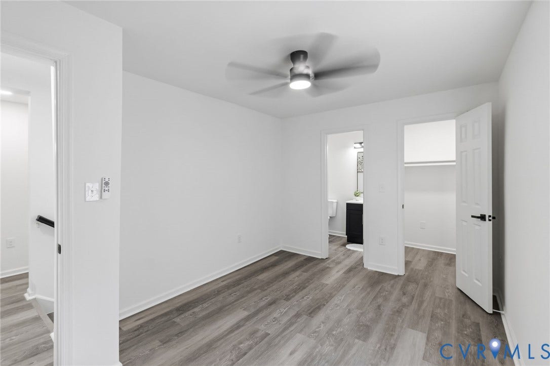 409 S Jefferson Street, Bolling, Petersburg, VA 23803 Spacious bedroom featuring wood-finish flooring, ceiling fan with integrated lighting, and multiple entry points
