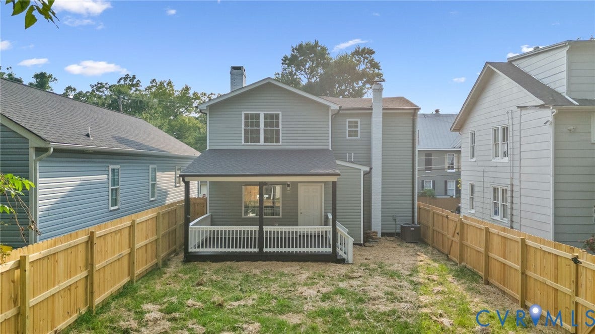 409 S Jefferson Street, Bolling, Petersburg, VA 23803 Exterior featuring light gray siding, white window trim, a covered porch with white railings, and a wooden privacy fence