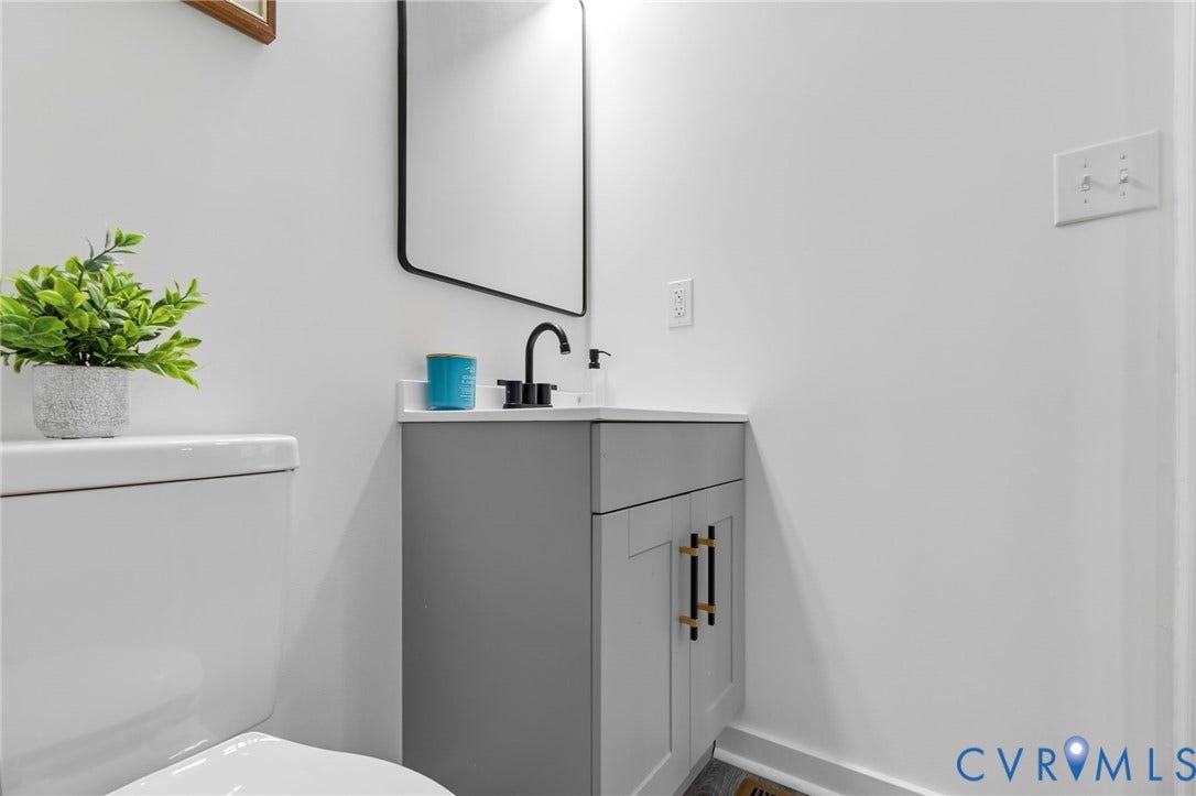 409 S Jefferson Street, Bolling, Petersburg, VA 23803 Modern vanity with matte black faucet, gray cabinetry, quartz-finish countertop, and rectangular mirror