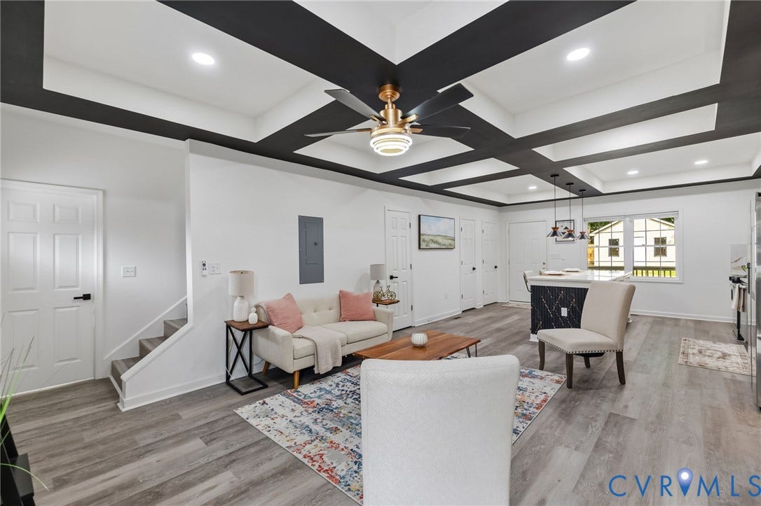 409 S Jefferson Street, Bolling, Petersburg, VA 23803 Coffered ceiling with a modern ceiling fan, wood-finish flooring, staircase with white risers, kitchen island with a dark stone-look finish, and pendant lighting