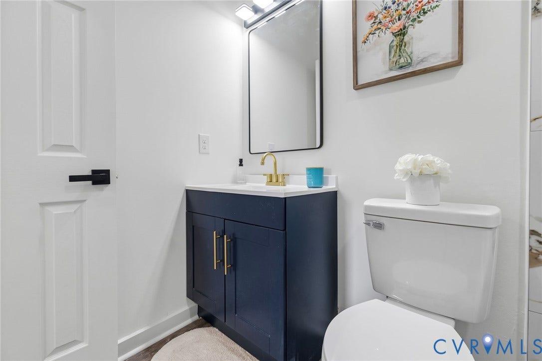 409 S Jefferson Street, Bolling, Petersburg, VA 23803 Vanity with dark blue cabinetry, gold-finish hardware, and a white countertop