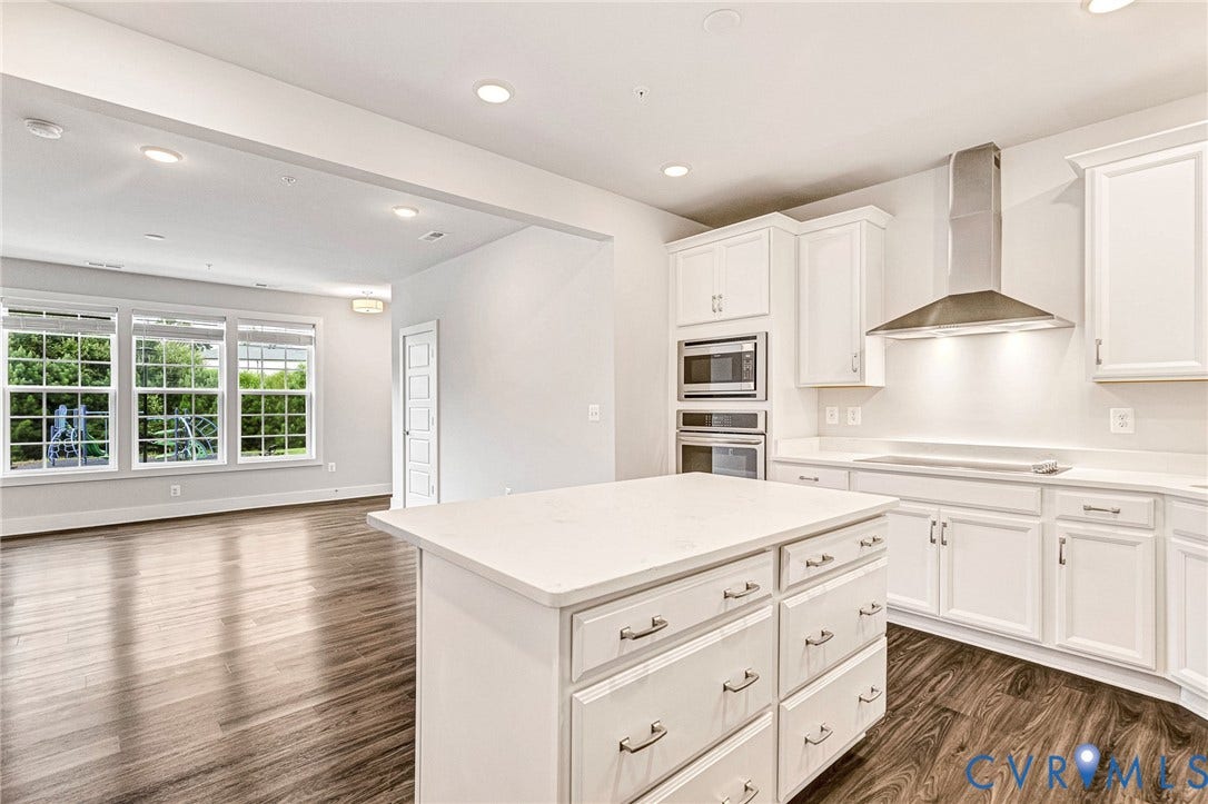 4347 Saunders Station Loop, #A, Glen Allen, VA 23233 Contemporary kitchen featuring white cabinetry, stainless steel appliances including dual wall ovens and a range hood, white quartz countertops, and a large center island with storage drawers