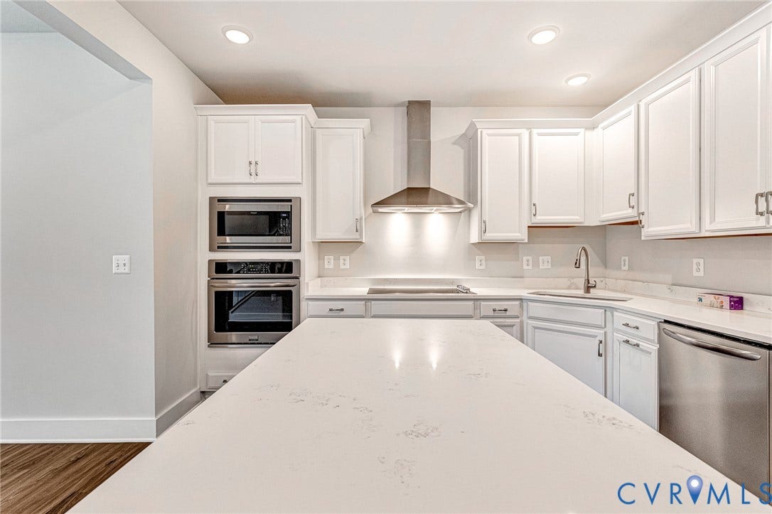 4347 Saunders Station Loop, #A, Glen Allen, VA 23233 Kitchen featuring white cabinetry, stainless steel appliances, a center island with a stone countertop, recessed lighting, and wood-finish flooring