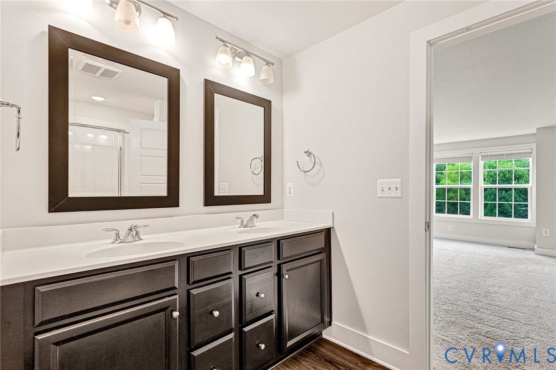4347 Saunders Station Loop, #A, Glen Allen, VA 23233 Dual vanity bathroom featuring dark cabinetry with brushed nickel hardware, white quartz countertops, and framed mirrors with integrated lighting
