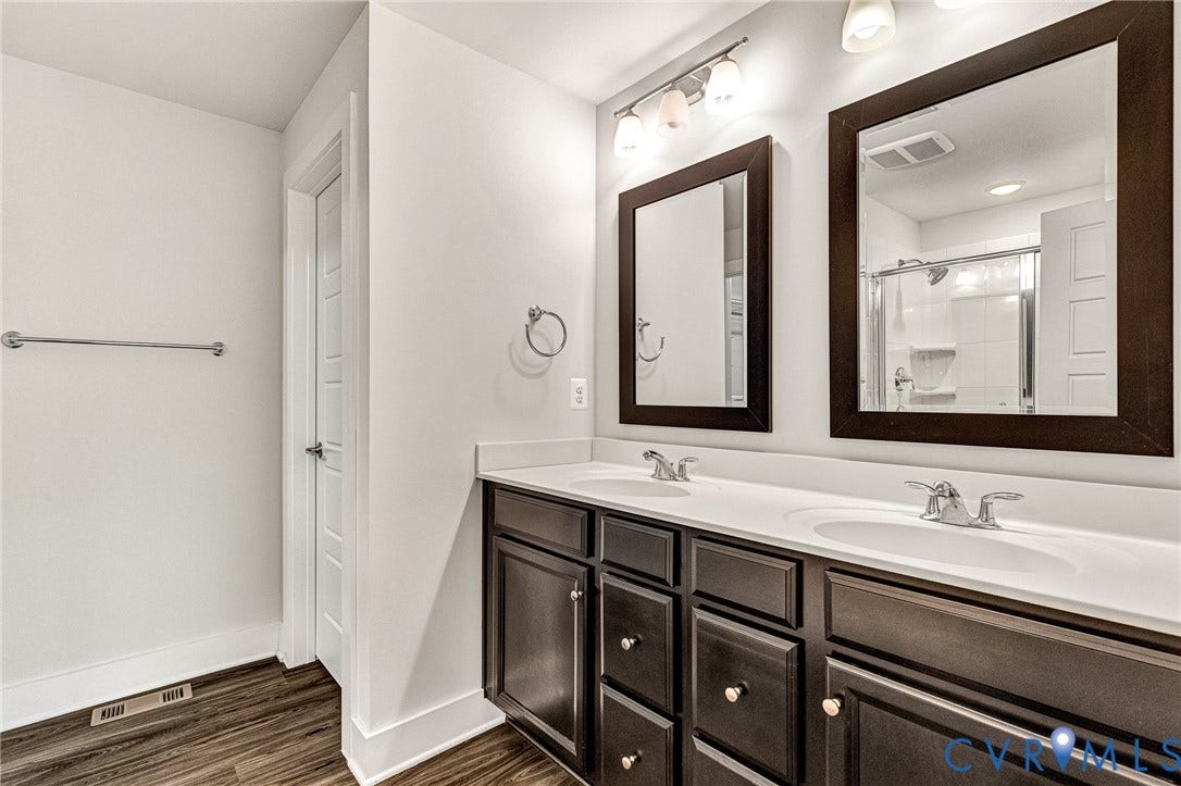 4347 Saunders Station Loop, #A, Glen Allen, VA 23233 Spa-inspired master bathroom featuring dual vanities with wood-finish cabinetry, white quartz countertops, and polished chrome fixtures