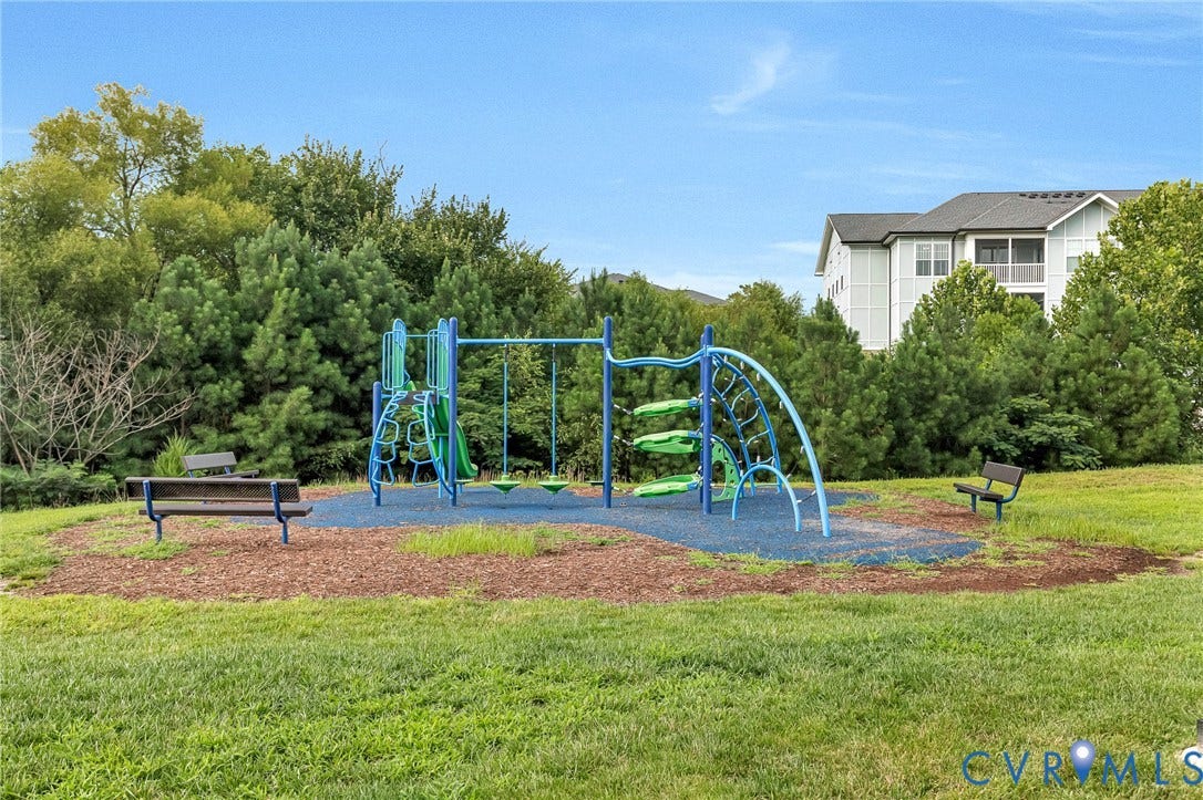 4347 Saunders Station Loop, #A, Glen Allen, VA 23233 Expansive backyard oasis featuring a modern blue playground structure with climbing elements and slide, bordered by mature landscaping and shade trees