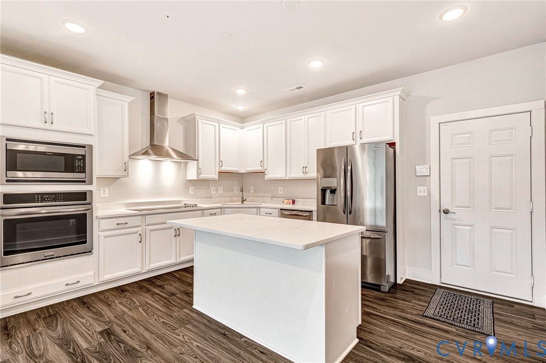 4347 Saunders Station Loop, #A, Glen Allen, VA 23233 Kitchen featuring white cabinetry, stainless steel appliances, a center island with a light-toned countertop, and wood-finish flooring
