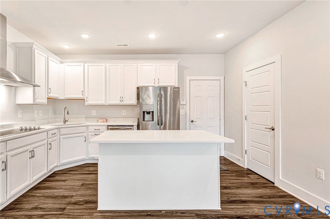 4347 Saunders Station Loop, #A, Glen Allen, VA 23233 Kitchen featuring wood-finish flooring, recessed lighting, white cabinetry, a stainless steel refrigerator, and a kitchen island with a light-toned countertop