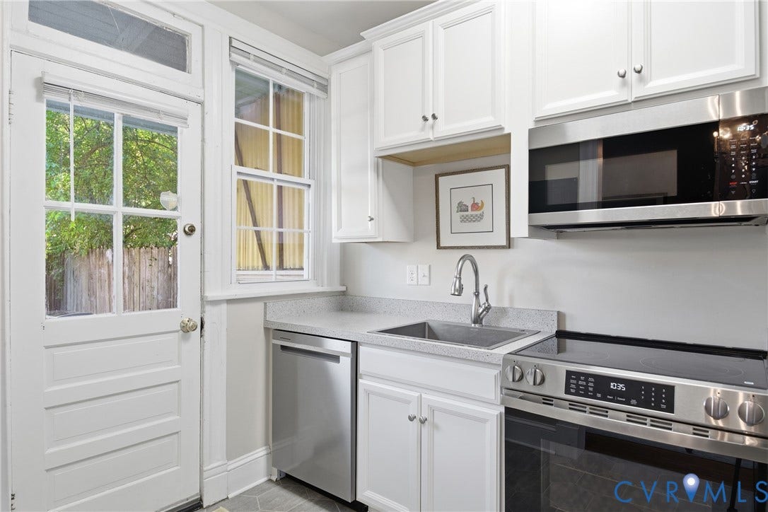 212 S Belmont Avenue, Carytown, Richmond, VA 23221 White cabinetry, stainless steel appliances, single basin sink, light-toned countertops, and a full-light paneled door