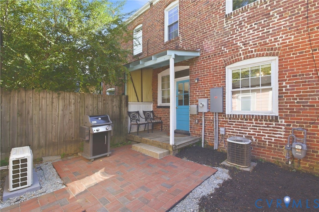 212 S Belmont Avenue, Carytown, Richmond, VA 23221 Brick exterior with a covered entry, paver patio, and wood privacy fencing
