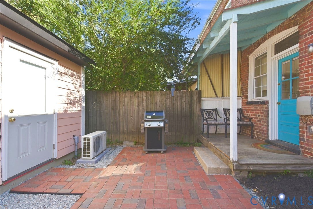 212 S Belmont Avenue, Carytown, Richmond, VA 23221 Brick patio with gravel edging, wood privacy fence, and covered porch with wood decking