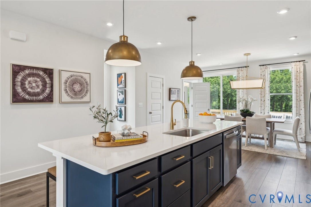 Kitchen island with an undermount sink, brass faucet, and built-in dishwasher