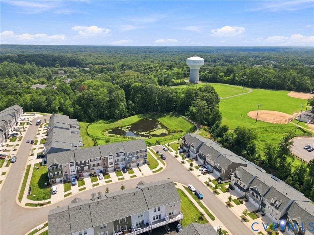 13820 Village View Drive, Midlothian, VA 23114 Aerial representation of a residential community with multi-level townhomes, a pond, and expansive green spaces