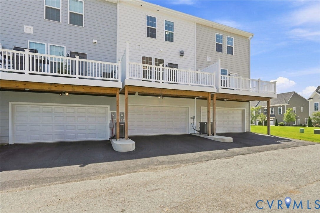 13820 Village View Drive, Midlothian, VA 23114 Multi-level townhouse exterior featuring multiple garage bays, individual decks, and gray horizontal siding