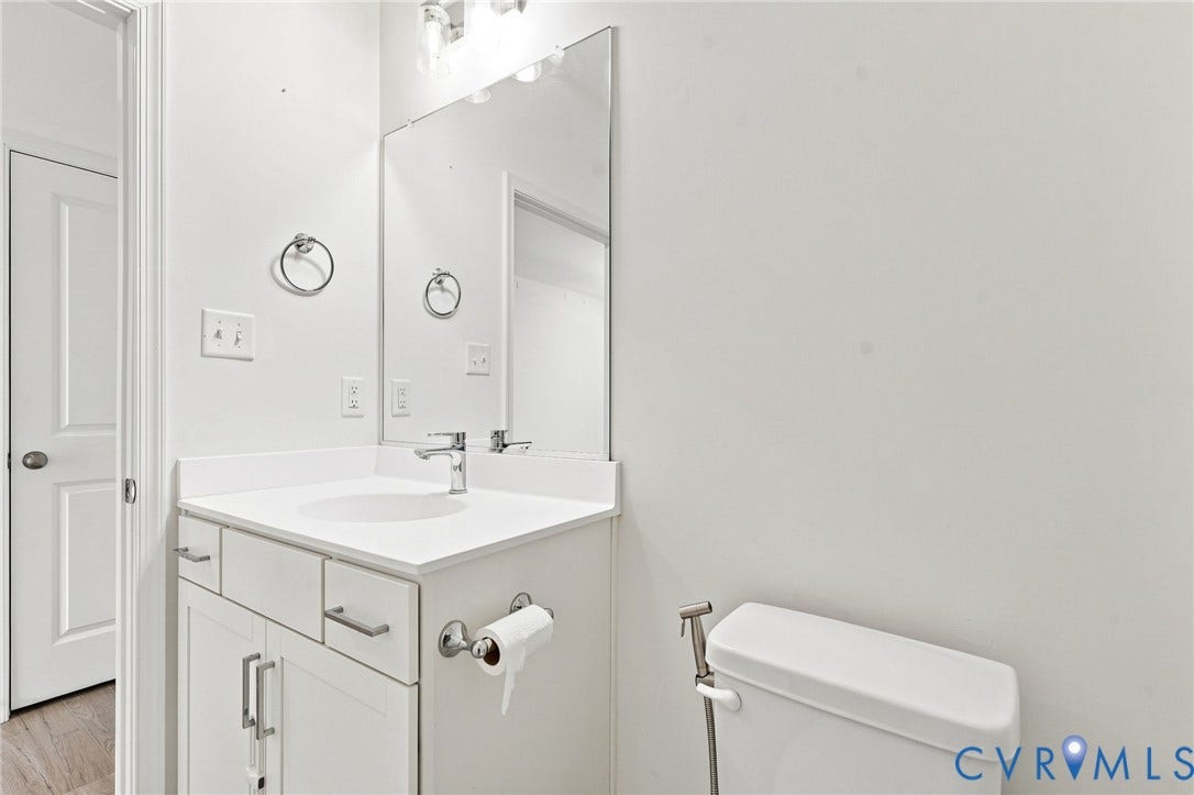 13820 Village View Drive, Midlothian, VA 23114 Vanity with an integrated sink, polished chrome faucet, built-in cabinetry, wall-mounted mirror, and overhead vanity lighting