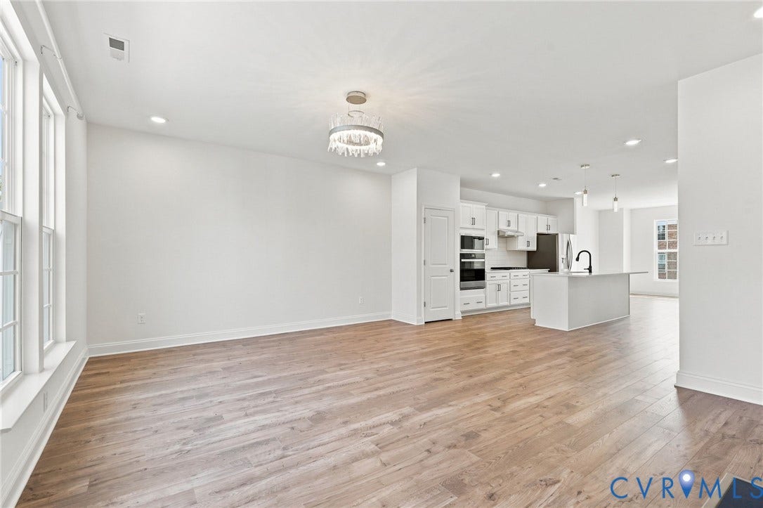 13820 Village View Drive, Midlothian, VA 23114 Open-concept living space featuring wood-finish flooring, recessed lighting, and a modern chandelier