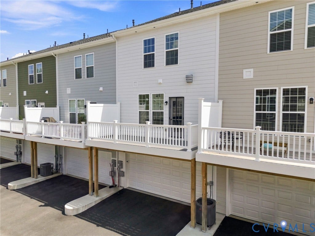 13820 Village View Drive, Midlothian, VA 23114 Multi-level townhome featuring white siding, private elevated deck with white railing, and an attached garage with paved driveway