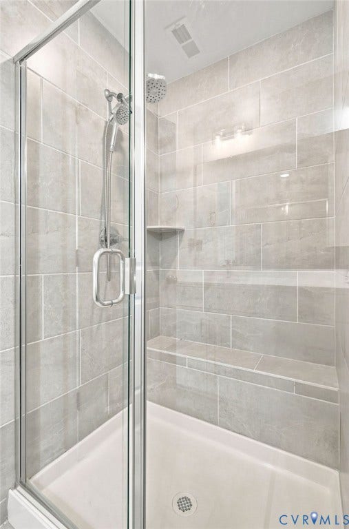13820 Village View Drive, Midlothian, VA 23114 Glass-enclosed shower with tiled walls, integrated shelving, and a built-in bench