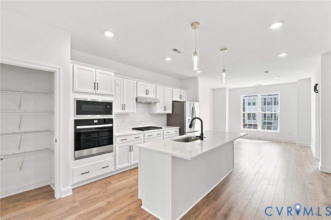 13820 Village View Drive, Midlothian, VA 23114 Kitchen featuring white shaker cabinets, stainless steel appliances, a center island with sink, and wood-finish flooring