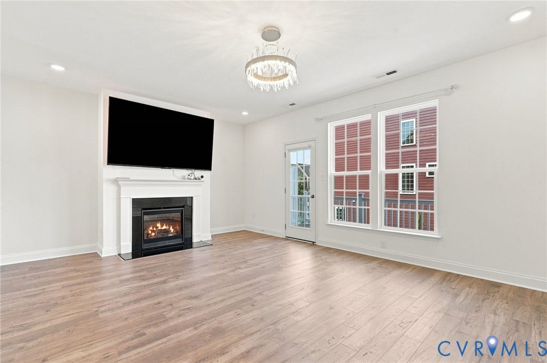 13820 Village View Drive, Midlothian, VA 23114 Wood-finish flooring, recessed lighting, and a fireplace with a white mantel and black surround