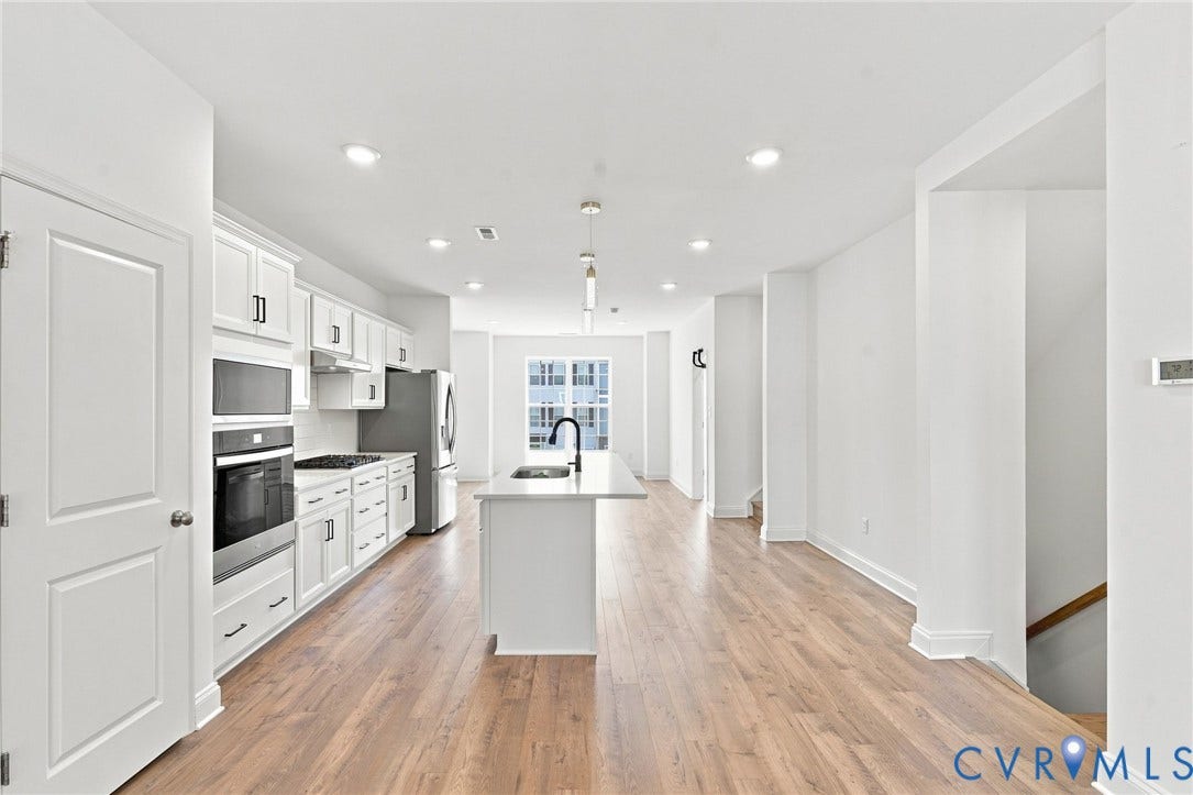 13820 Village View Drive, Midlothian, VA 23114 Open-concept kitchen with white shaker cabinetry, stainless steel appliances, and a central island with a sink and pendant lighting