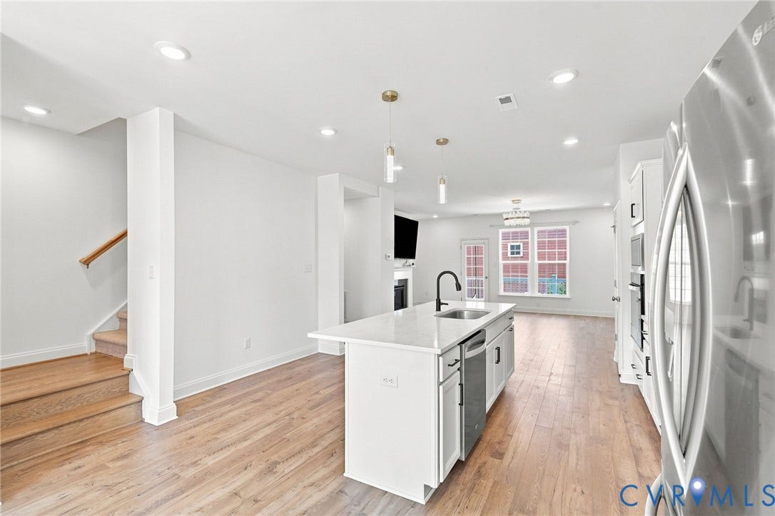13820 Village View Drive, Midlothian, VA 23114 Open-concept layout featuring wood-finish flooring throughout, a central kitchen island with seating, recessed lighting, and stainless steel appliances