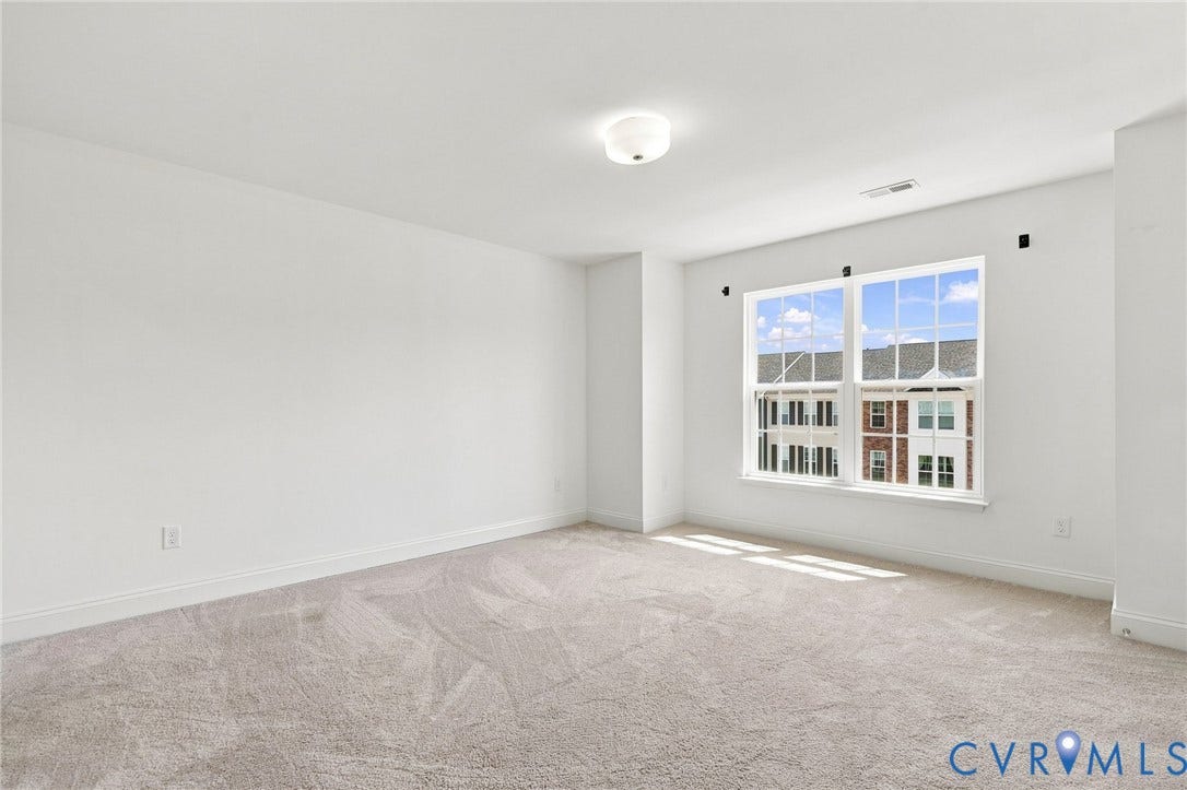 13820 Village View Drive, Midlothian, VA 23114 Expansive room featuring light-colored carpeting, white wall finishes, a large multi-pane window, and a flush-mount ceiling light fixture