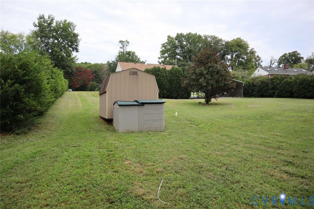 12853 Holly Lane, Manakin Sabot, VA 23103 Expansive green space with manicured lawn, established shrubs, and a mature tree