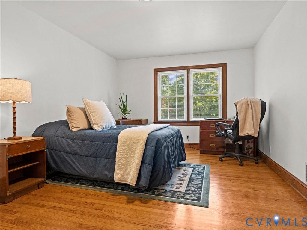 Primary Bedroom with hardwood floors, full bath and walk in closet