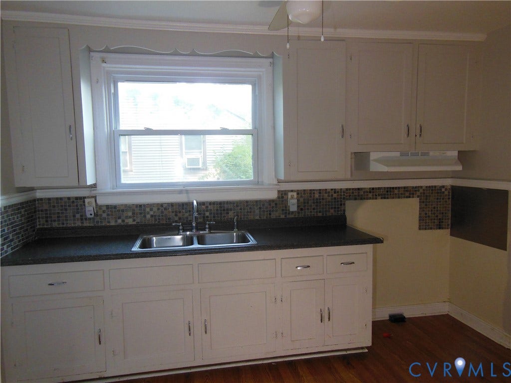 5307 Media Road, Richmond, VA 23225 White cabinetry, dual-basin stainless steel sink, tile backsplash, laminate countertops, and wood-finish flooring