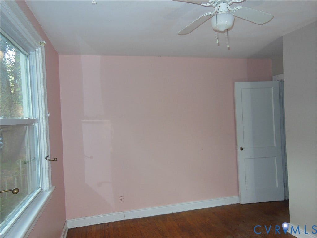 5307 Media Road, Richmond, VA 23225 Wood-finish flooring, white window trim, and white paneled door