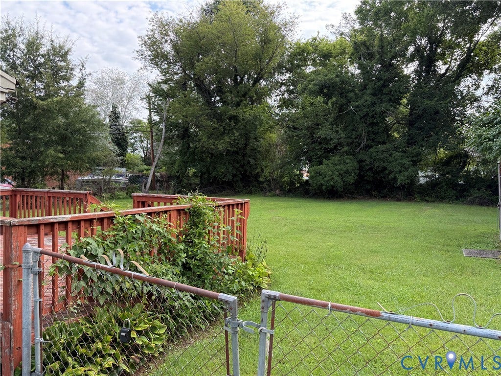 5101 Montpelier Street, Richmond, VA 23231 Expansive green lawn with mature trees and a wood-finish deck with railings