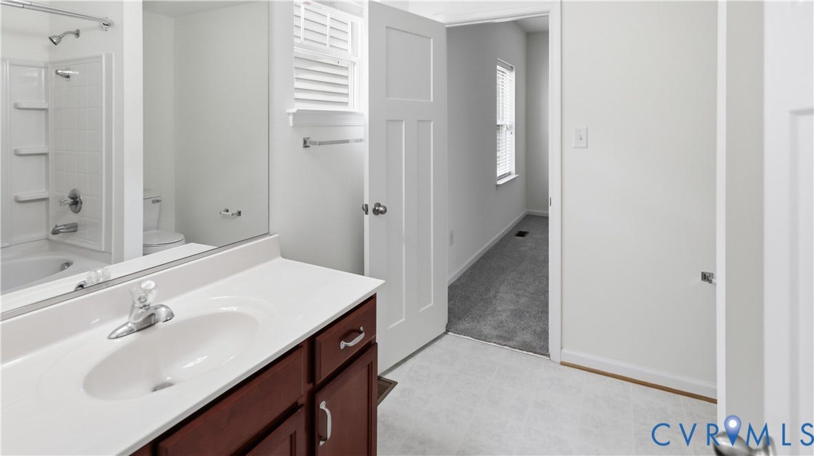 Single vanity with a white countertop and dark wood-finish cabinetry