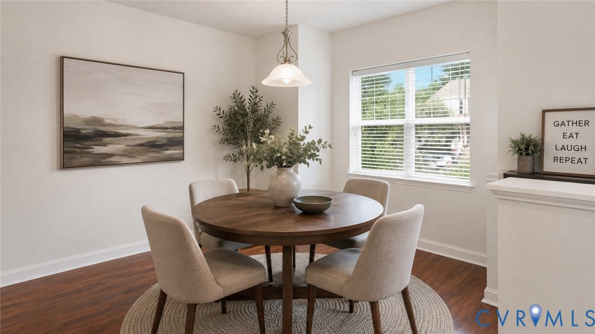 Recessed dining area with wood-finish flooring, a pendant light fixture, and natural light from a window. virtually staged