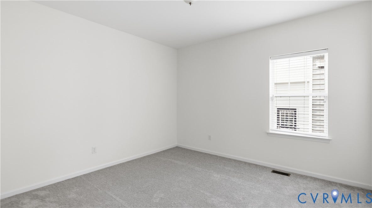 Neutral wall color, carpet flooring, window with blinds, and white trim