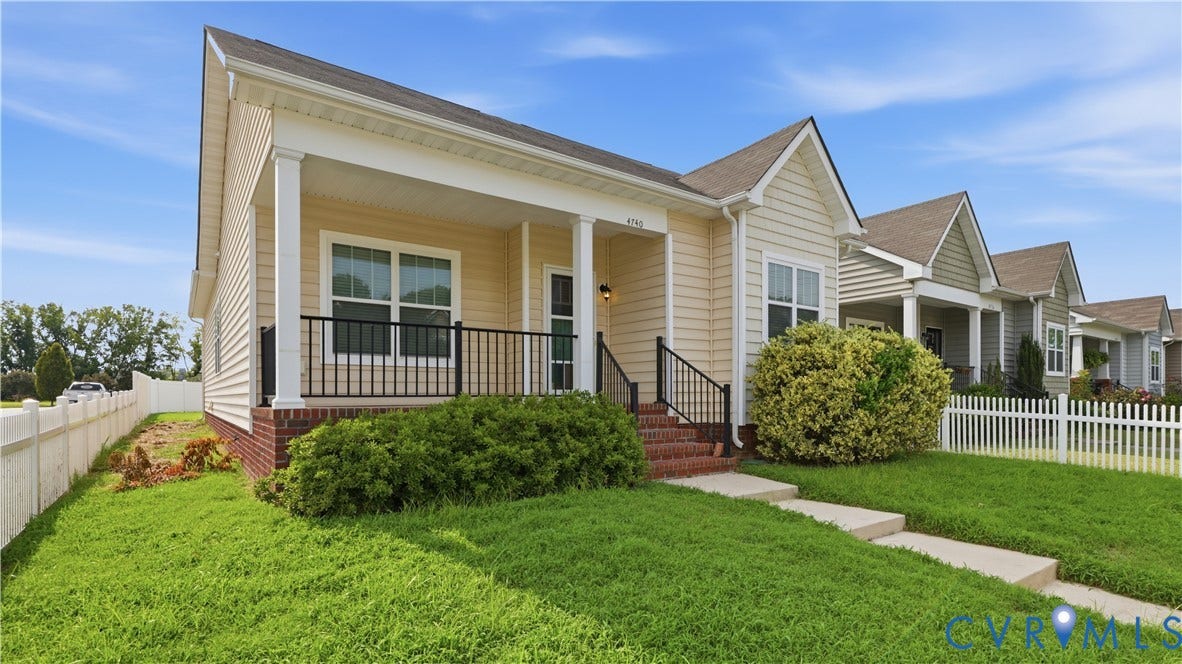 Property exterior featuring a covered porch with white columns, brick foundation, and light-toned siding