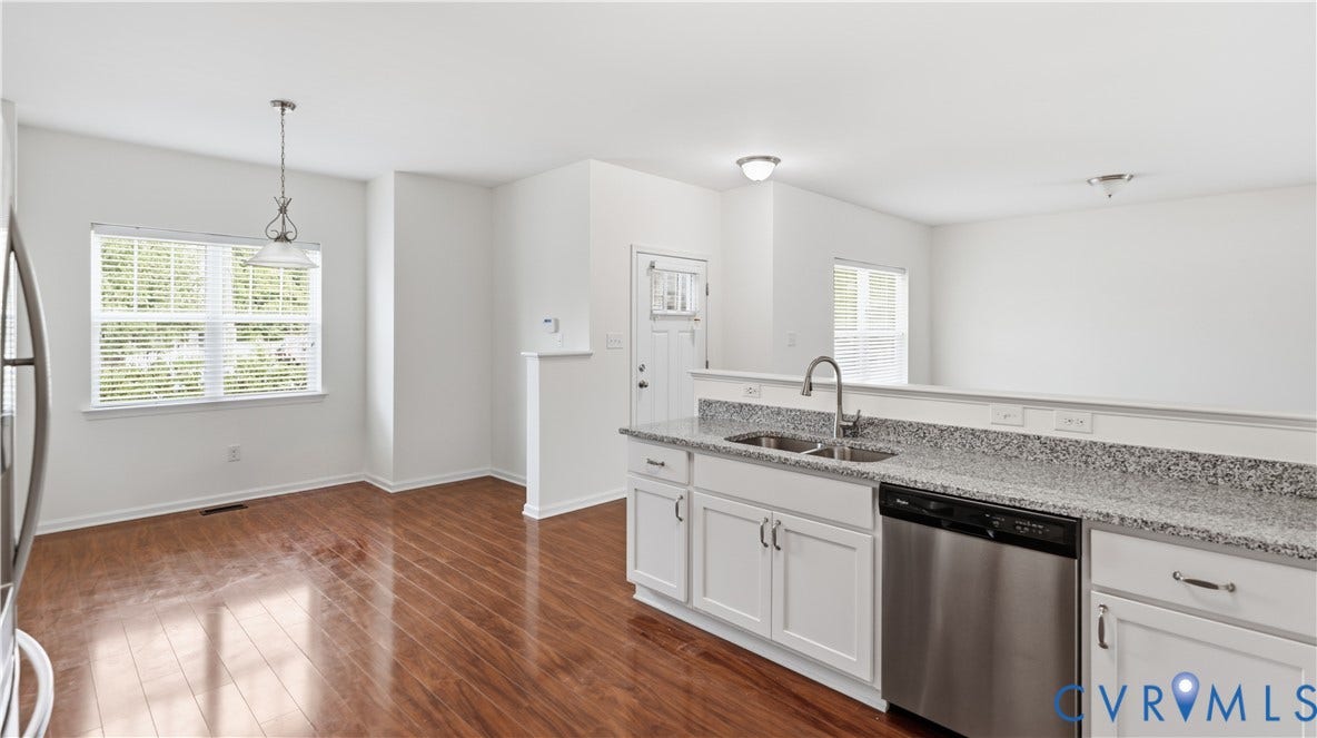 Kitchen featuring white cabinetry, stainless steel appliances, dual basin sink, and stone-finish countertops