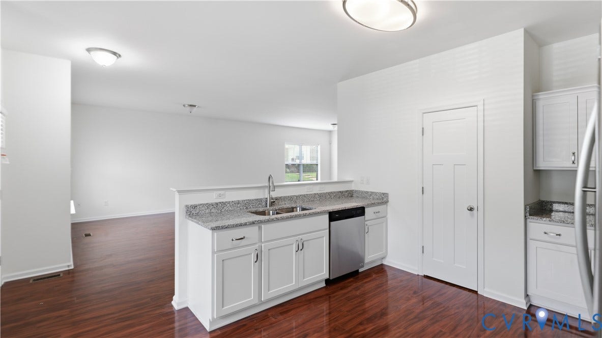 Kitchen island with an undermount sink, gooseneck faucet, and light-toned countertop