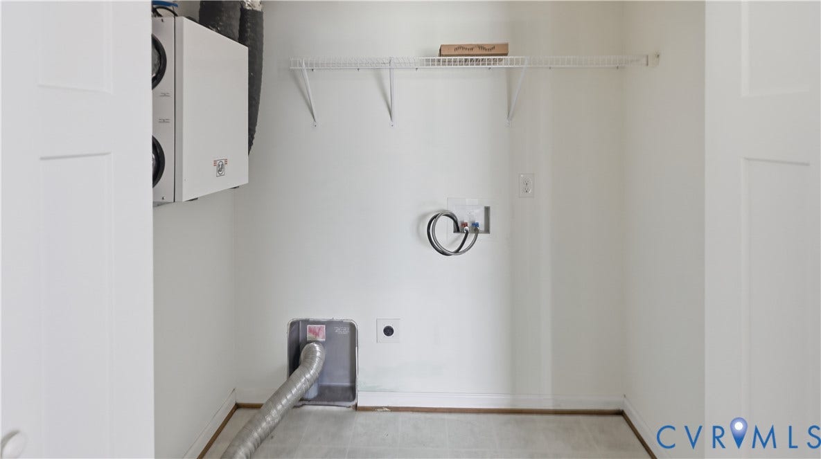 Dedicated utility space with white walls, wire shelving, and wood-finish flooring