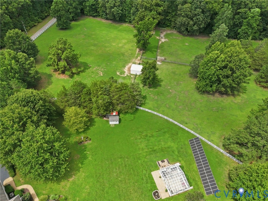 2365 Manakintown Ferry Road, Powhatan, VA 23113 Expansive grounds featuring manicured lawn surrounded by mature trees, solar panel array, detached outbuilding, and paved pathway connecting multiple structures across the property