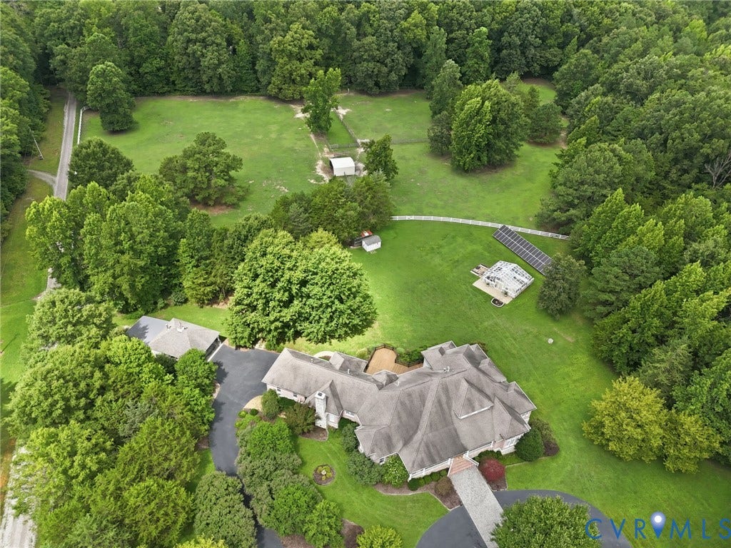 2365 Manakintown Ferry Road, Powhatan, VA 23113 Extensive green acreage bordered by mature trees, featuring a large residence with a multi-gabled roof, paved circular driveway, and a detached garage